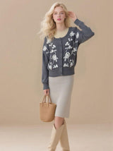 Women's embroidered cardigan sweater with front button placket and cable knit design.